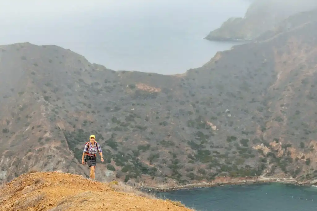 A woman is hiking on Catalina Island above Cat Harbor